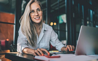 Frau am Computer zur Veranschaulichung von Weiterbildungsmaßnahmen innerhalb eines Unternehmens