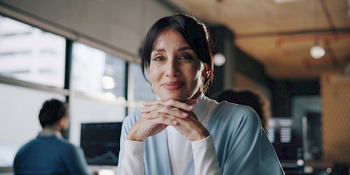 Business woman looks into camera to illustrate upskilling