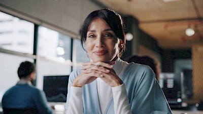 Business woman looks into camera to illustrate upskilling