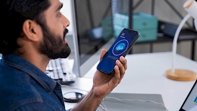 Man talking to AI on mobile phone to illustrate AI in the office