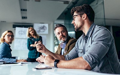 Mitarbeiter im Meeting zur Visualisierung von KI Kompetenzen